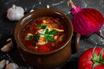 borsch in a clay pot with sour cream, brown bread and fresh herbs