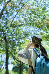 新緑の登山を楽しむ若い女性