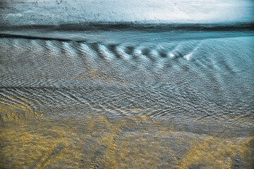 Water of the Andaman sea is forming different shapes when reaching the sandy Cenang beach