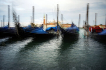 Obraz premium Venice, Italy - August 25, 2018. Gondolas at the pier overlooking the San Giorgio Maggiore. Gondolas at the pier in Venice.