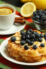 Belgian waffles with blueberry and a cup of tea with lemon