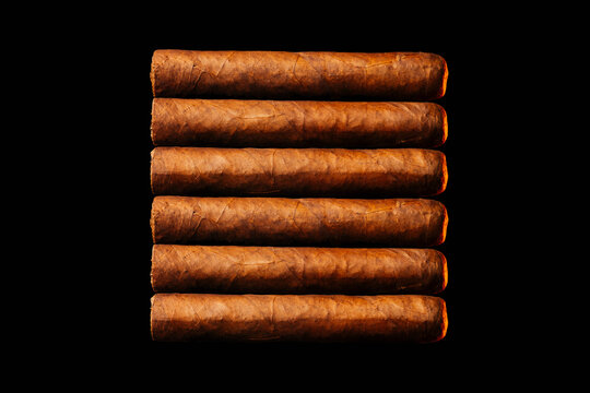 Beautifully infseen Cuban cigars lie on a dark background view from above