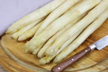 asperges blanches fraîches sur une planche à découper
