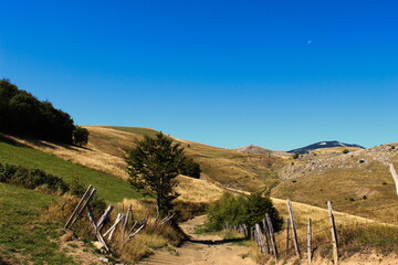 Idyllic view in autumn, on an old mountain road with an old fence and mountain peaks in the background. Bjelasnica Mountain, Bosnia and Herzegovina..