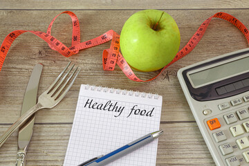 Notepad with cutlery and a calculator for counting calories