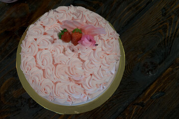 Pink roses buttercream cake with fresh strawberries. Top view.