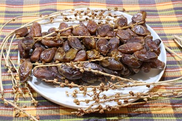 Dates are sweet, tasty and healthy on a large white plate on the table