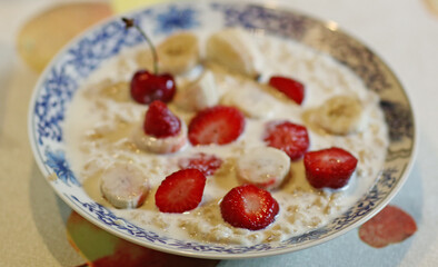 healthy breakfast - porridge with fruit strawberry, banana and cherry