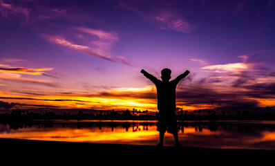 Amazing sunset and sunrise.Dark tree on open field dramatic sunrise.Panorama.Countryside Landscape Under Scenic Colorful Sky At Sunset Dawn.With the silhouette of the boy.