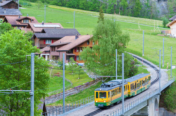 Train run through village in Lauterbrunnen valley in Switzerland
