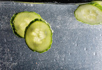 Water drops on ripe cucumber. Fresh vegetables background with copy space for your text. Vegan concept.