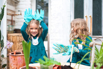 Stay at home. Home gardening in the greenhouse. Girls sisters and house plants. Urban jungle.