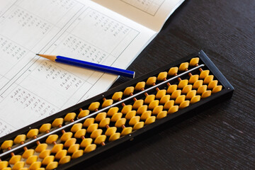 Abacus (Japanese traditional calculator), text and pencil.