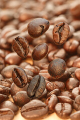 Dark roasted coffee beans falling on the wood floor