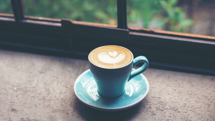 Work from home and Stay at home. Closeup cup hot coffee working in the work space near window, morning sunny day.  Vintage Tone.