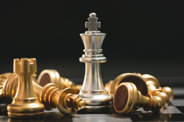 Human hand moving dark King chess piece at table