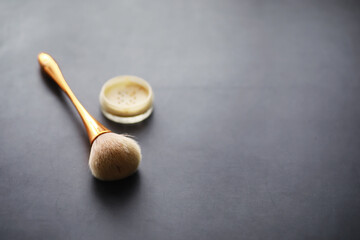 Powder and makeup brush. Brown powder on the background. Makeup products. Style concept.