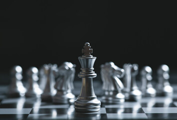 King of battle chess game stand on chessboard with black isolated background. Business leader concept.