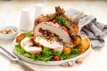 Stuffed boneless chicken garnished with fresh vegetables, lettuce, cherry tomatoes, bell peppers and fresh rosemary herbs