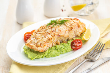 Salmon fillet fried in almond petals. Garnished with cauliflower and green peas puree.