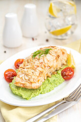 Salmon fillet fried in almond petals. Garnished with cauliflower and green peas puree.