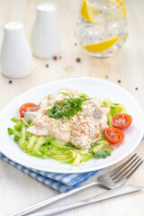 Salmon slices in creamy sauces and zucchini. Ketogenic food.