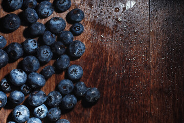 Water drops on ripe sweet blueberry. Fresh blueberries background with copy space for your text. Vegan and vegetarian concept. Macro texture of blueberry berries.