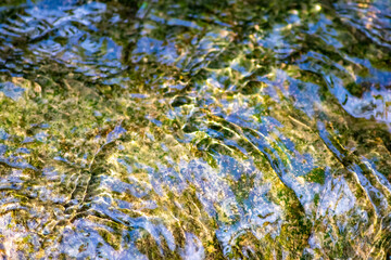 Klares Wasser einer sprudelnden Quelle mit sauberem Wasserfall und Bach mit seidigen Wellen für Entspannung und Meditation zeigen schöne Reflexionen auf der Wasseroberfläche mit unberührter Natur