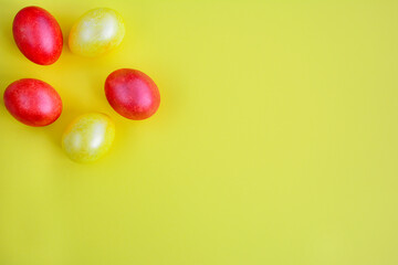 Bright red and yellow easter eggs on a yellow background. View from above