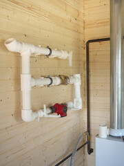 mounting of gravity heating system equipment with laser level in a boiler room. Circulation pump, stopcock, return valve, polypropylene tube and laser level
