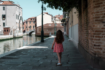 rear view of a cute little girl walking in venice