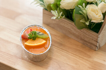 
Orange cakes put on wooden tary decorate the cake with fresh fruit, mix Orange, Strawberry and Kiwi slices and green leaves.