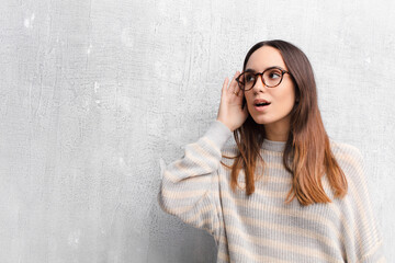 young pretty woman looking serious and curious, listening, trying to hear a secret conversation or...