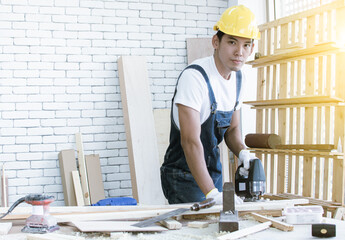A carpenter is making a hold on wood by using a drill