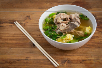 Triangular dumplings filled with pork, boiled in broth or water.