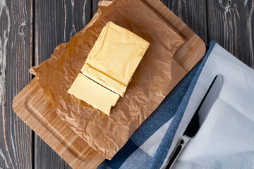 Cut butter on plate with blue towel on kitchen table
