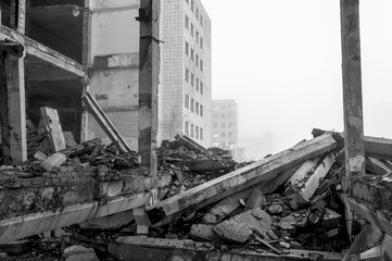 Black and white image. The destroyed big concrete building in a foggy haze. Background.
