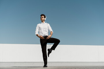 Ballet dancer with headphones practising on roof terrace
