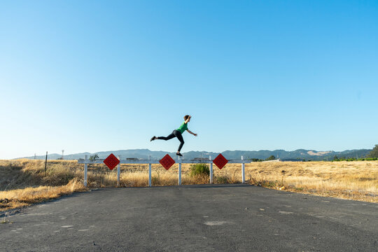 Acrobat balancing on barrier