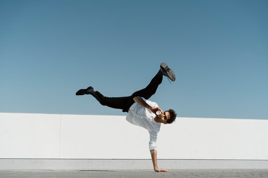 Artist drinking coffee to go while practising on roof terrace