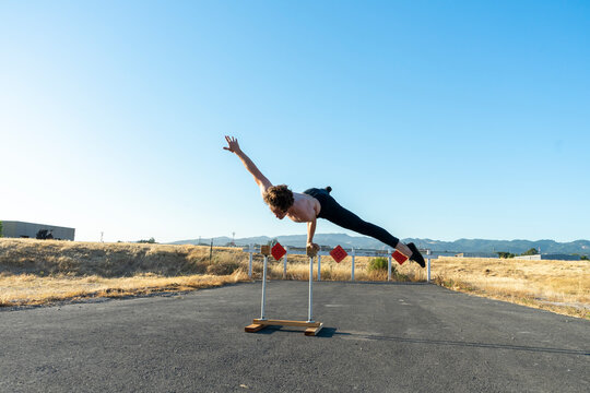 Acrobat balancing on handstand canes