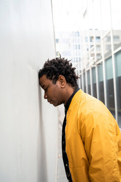 Man leaning with forehead on a wall