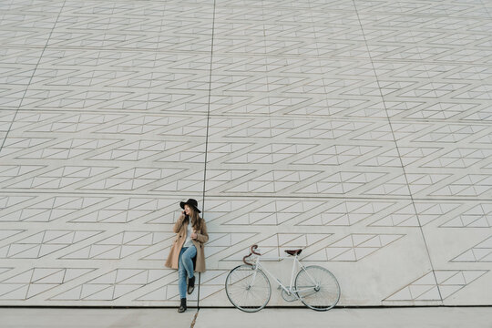 Young hipster woman speaking by phone near to a bicycle
