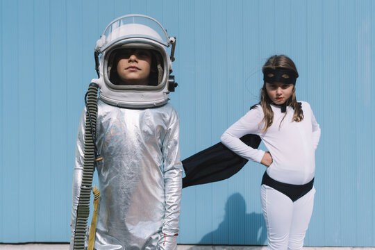 Two kids in astronaut and superhero costumes