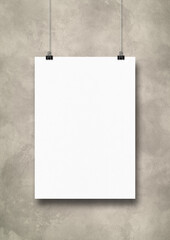 White poster hanging on a light concrete wall with clips