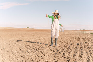 Young woman sowing field for the future