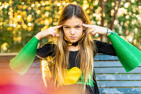 Girl posing in super heroine costume on a bench