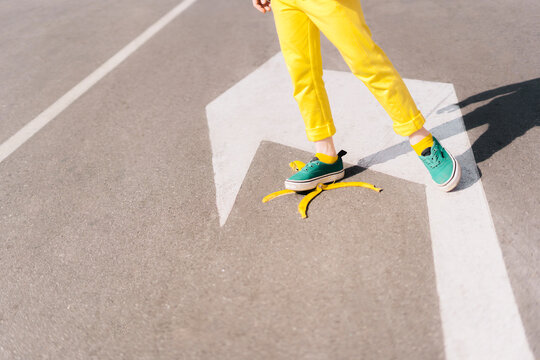 Girl stepping on banana peel on a street