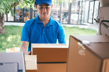 Delivery man loading cardboard boxes in a delivery van