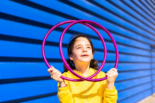 Portrait of little girl with gymnastic rings looking up